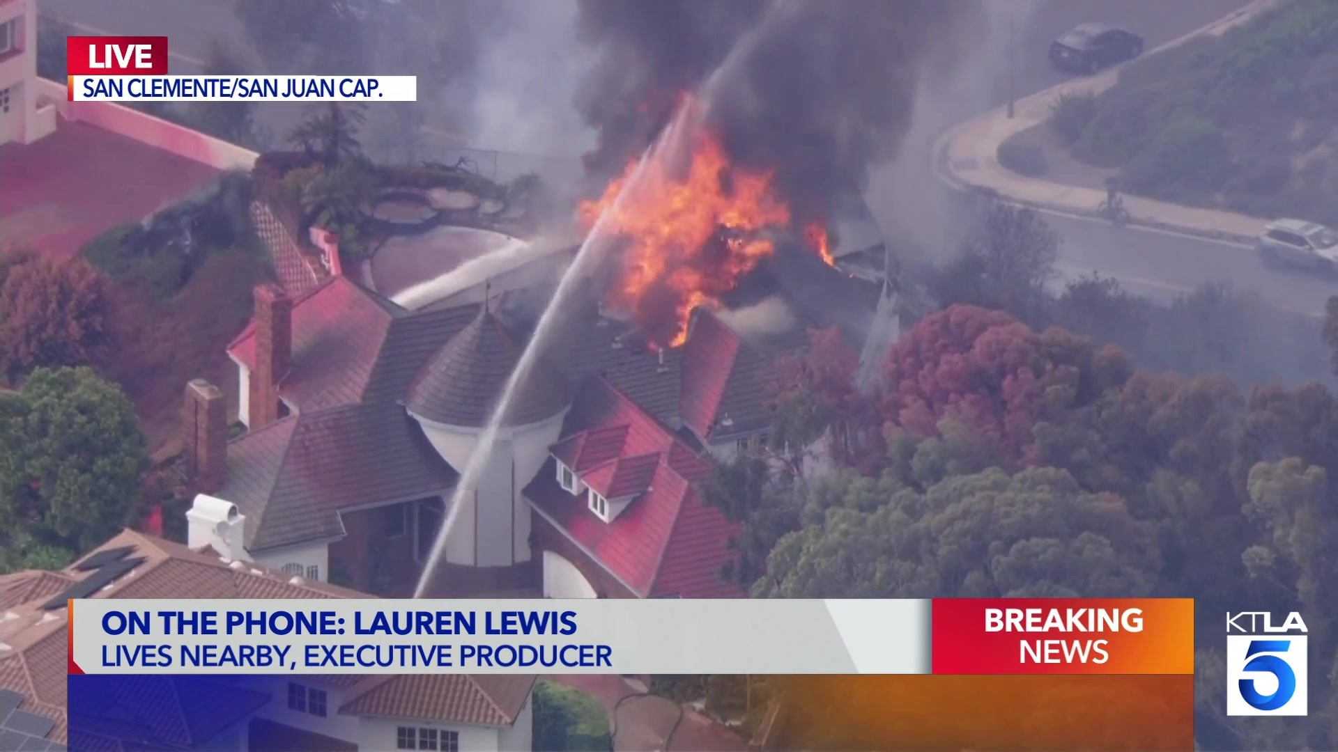 KTLA Sky5 still of firefighters spraying water on a burning home
