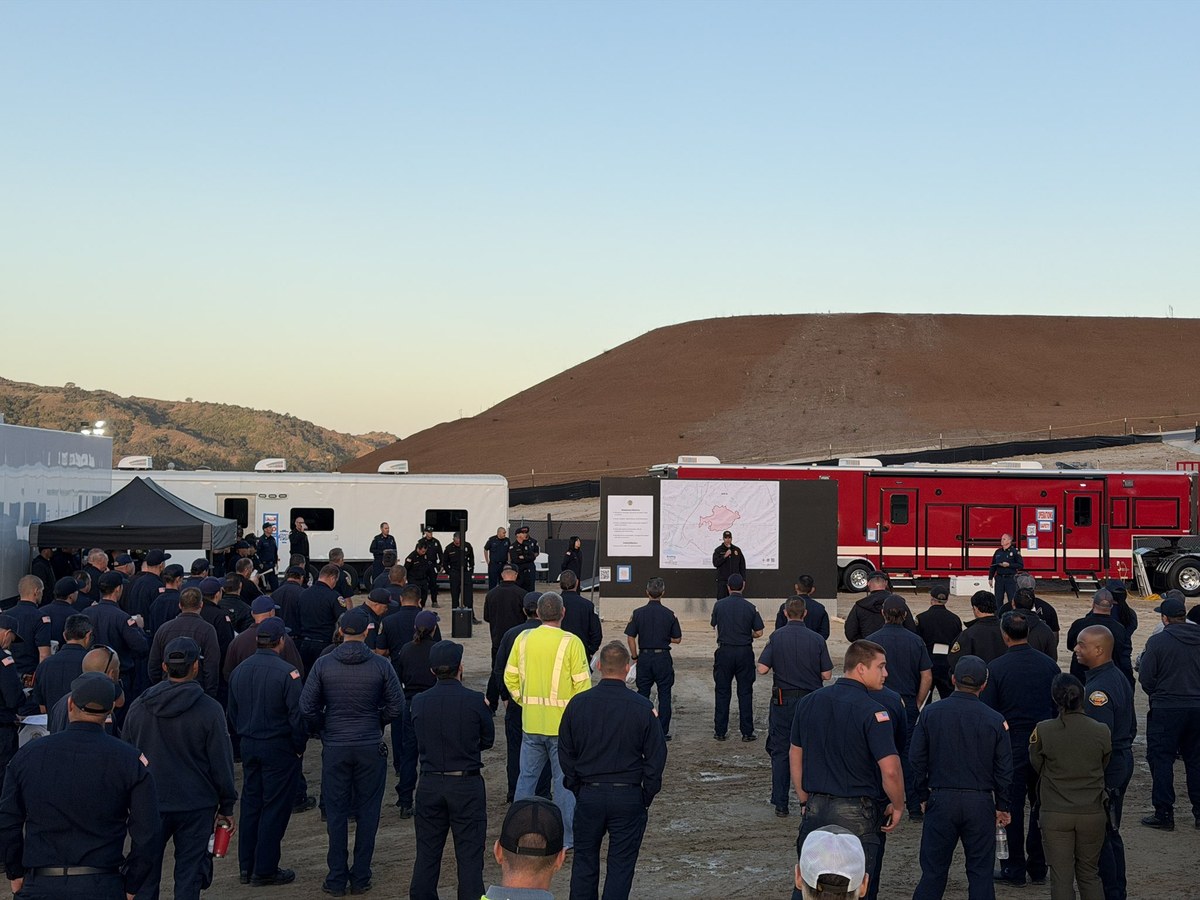 Firefighters and personnel gathered at the Norte Fire incident area at sunrise