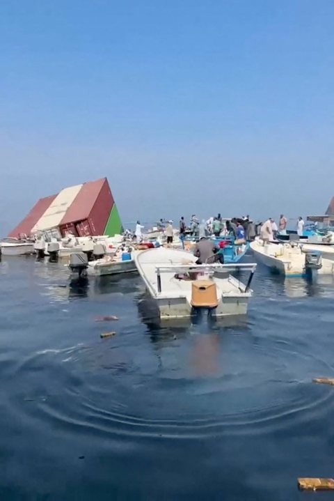 Small boats at the site where containers float after the GFS Pride sank